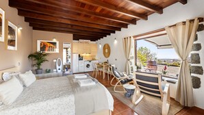 Un dormitorio con cama, escritorio y vistas al exterior.