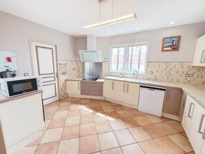 Een koelkast, een oven, een vaatwasser, kookgerei, borden en bestek