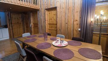 A dining area with a wooden table, purple placemats, and chairs.