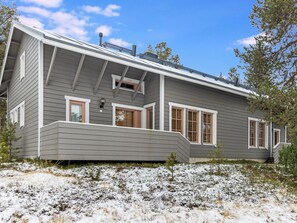 Une maison à deux étages, dotée d’un toit en pente, de nombreuses fenêtres et d’une cheminée.