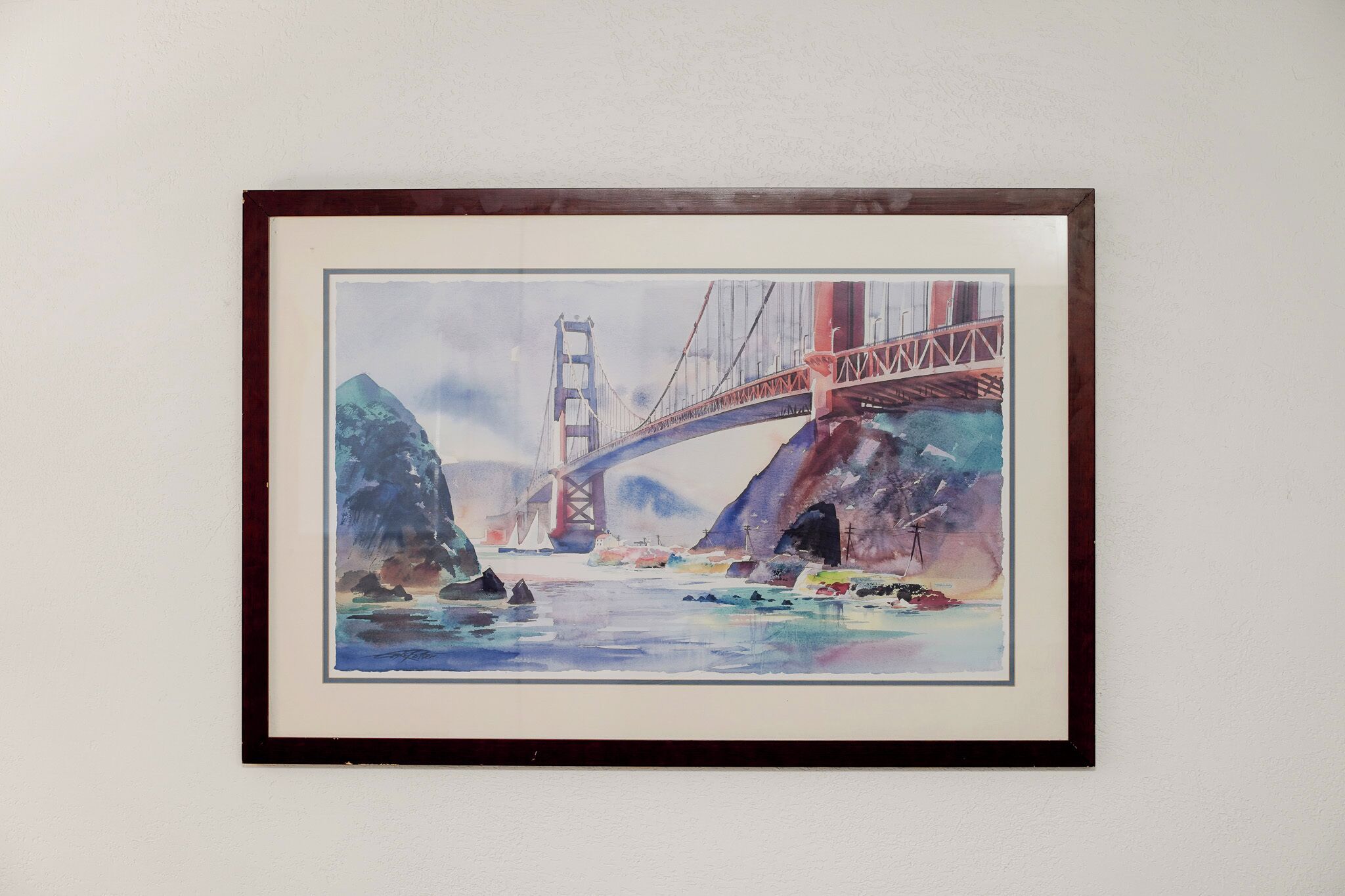 A framed painting of the Golden Gate Bridge.