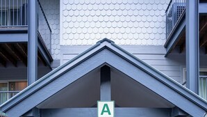 A building entrance with a sign indicating the entrance, a set of stairs, and a door with a glass panel. - Purgatory Townhomes 128, perfect for families in the heart of the Purgatory (Durango)