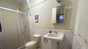 Un baño con inodoro, lavamanos y ducha.