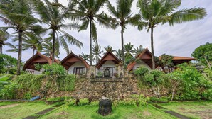 Un resort con varias construcciones tipo bungalow, cada una con fachada de piedra y techo de madera.