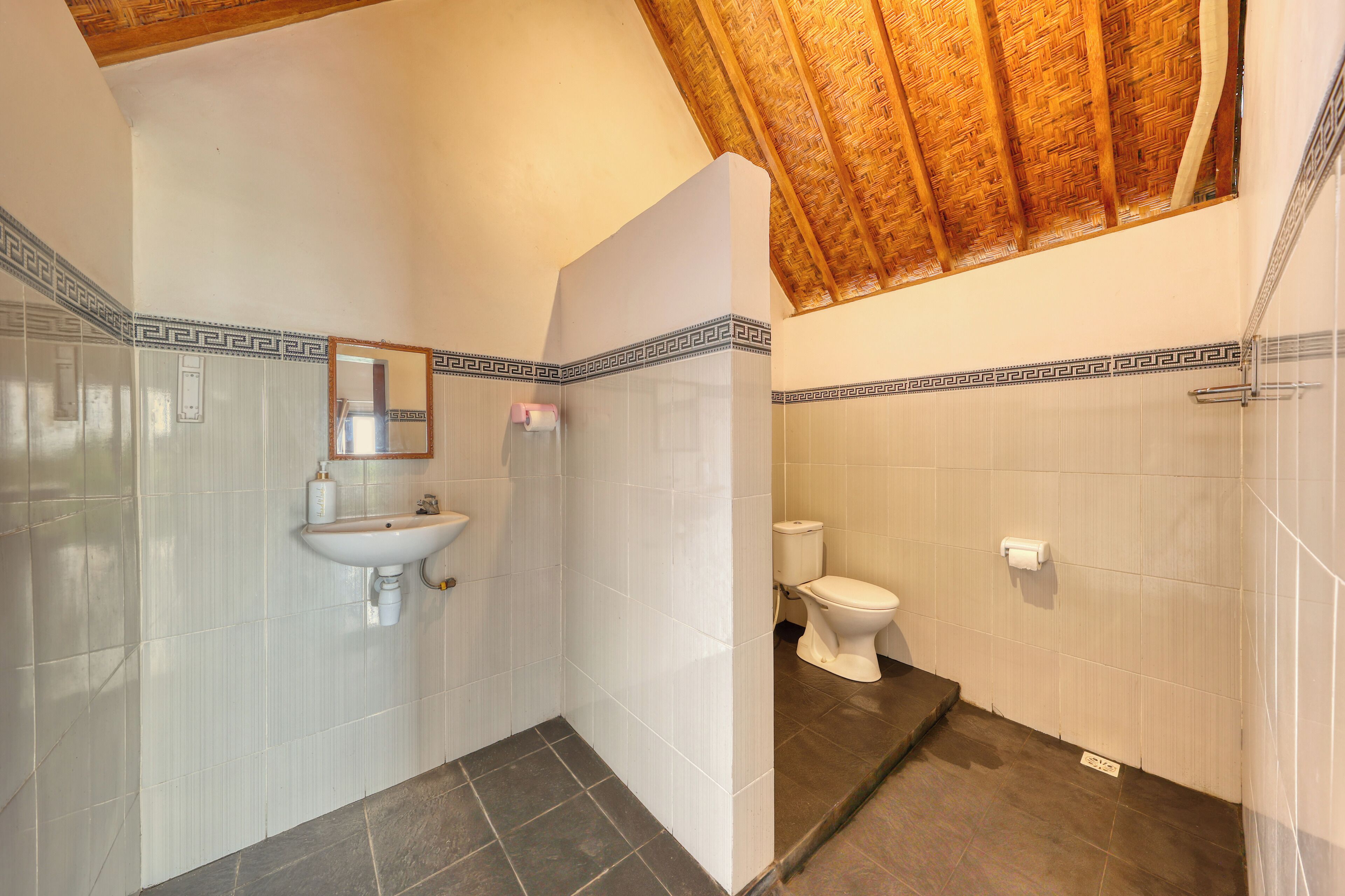 Un baño con lavamanos, inodoro y zona de ducha.