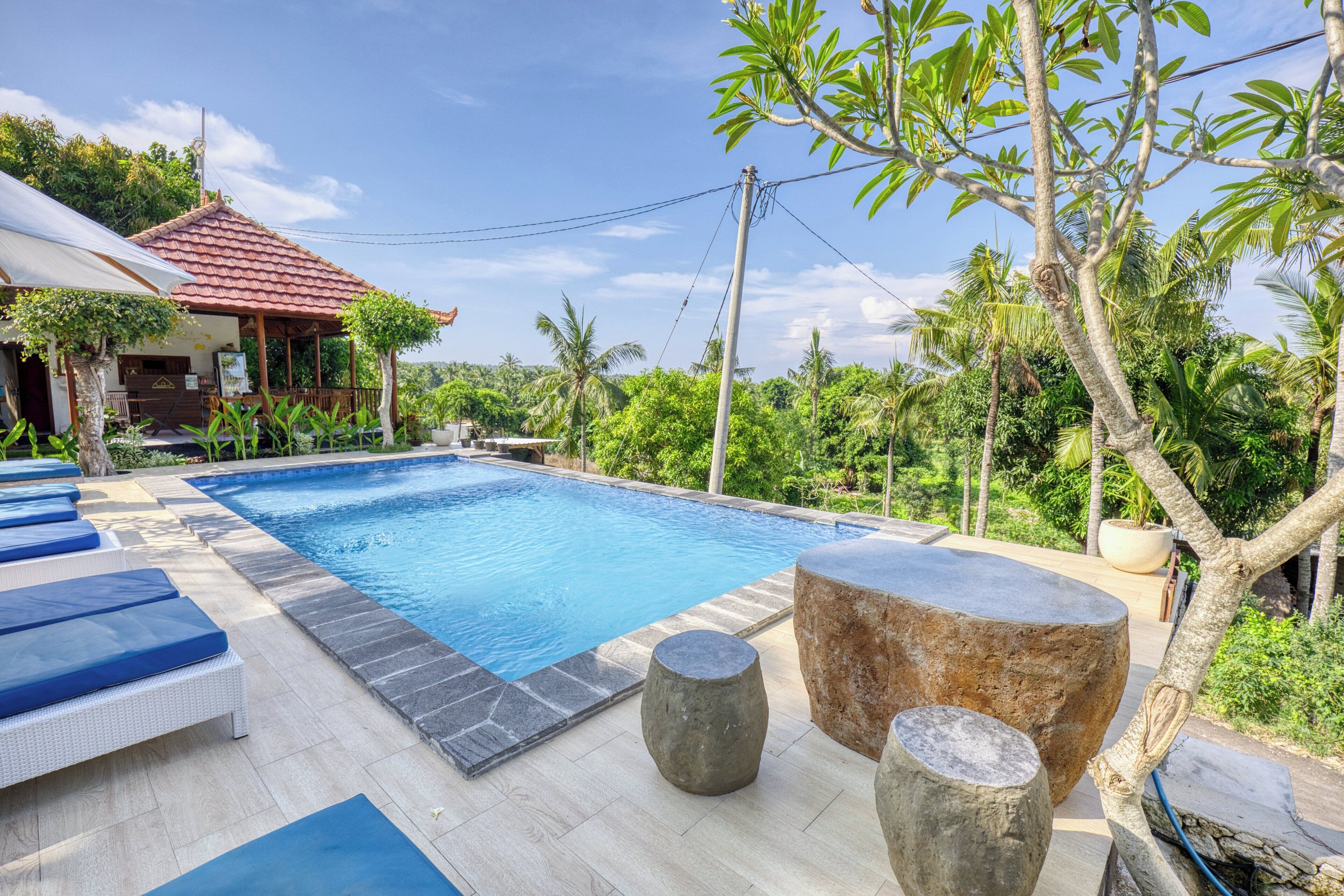 A swimming pool with lounge chairs and a stone structure.