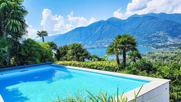 Una piscina con vistas a montañas y un lago.