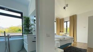 A modern bedroom with a bed, bedside table, and a view of greenery outside. - Nicme Villa Bran: Game Room and Barbecue (Bran)