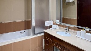 Un bagno moderno con una vasca, un lavandino e un grande specchio.