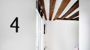 A room with a white wall, a wooden ceiling, and a white radiator. - Quiet Studio for 2 People - Le Marais (Paris)