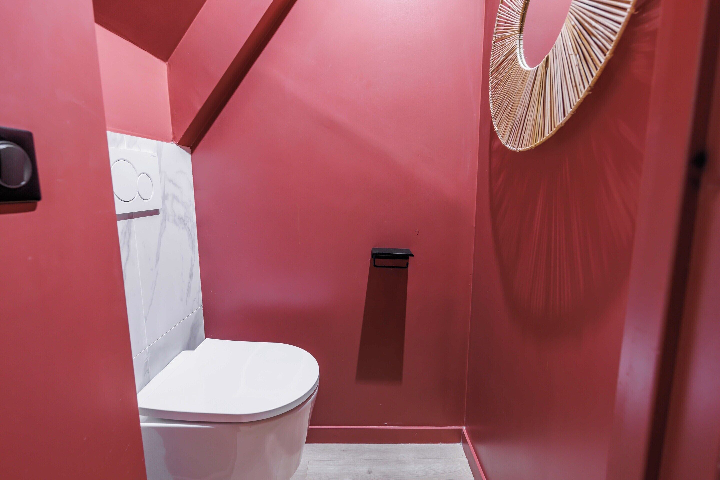 A bathroom with a white toilet, a shower, and a wall-mounted towel rack.