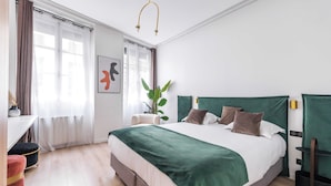 A neatly arranged bedroom with a large bed, a desk, and a chair. - Charming Duplex - 2br/6p - In the Heart of Odeon (Paris)