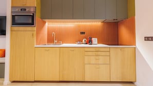A modern kitchen with wooden cabinets, a built-in oven, and a stainless steel sink. - Charming Duplex - 2br/6p - In the Heart of Odeon (Paris)