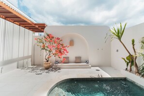 A modern outdoor pool area with a seating bench, a potted plant, and a clear sky. - Villa Sari 1 by Alfred in Bali (Pecatu)
