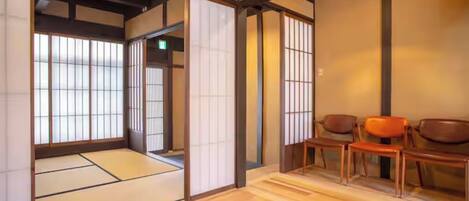 A traditional Japanese room with tatami flooring, sliding doors, and wooden furniture.