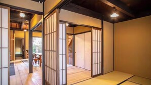 Ein traditioneller japanischer Raum mit Tatami-Bodenbelag, Schiebetüren und einer Holzdecke.