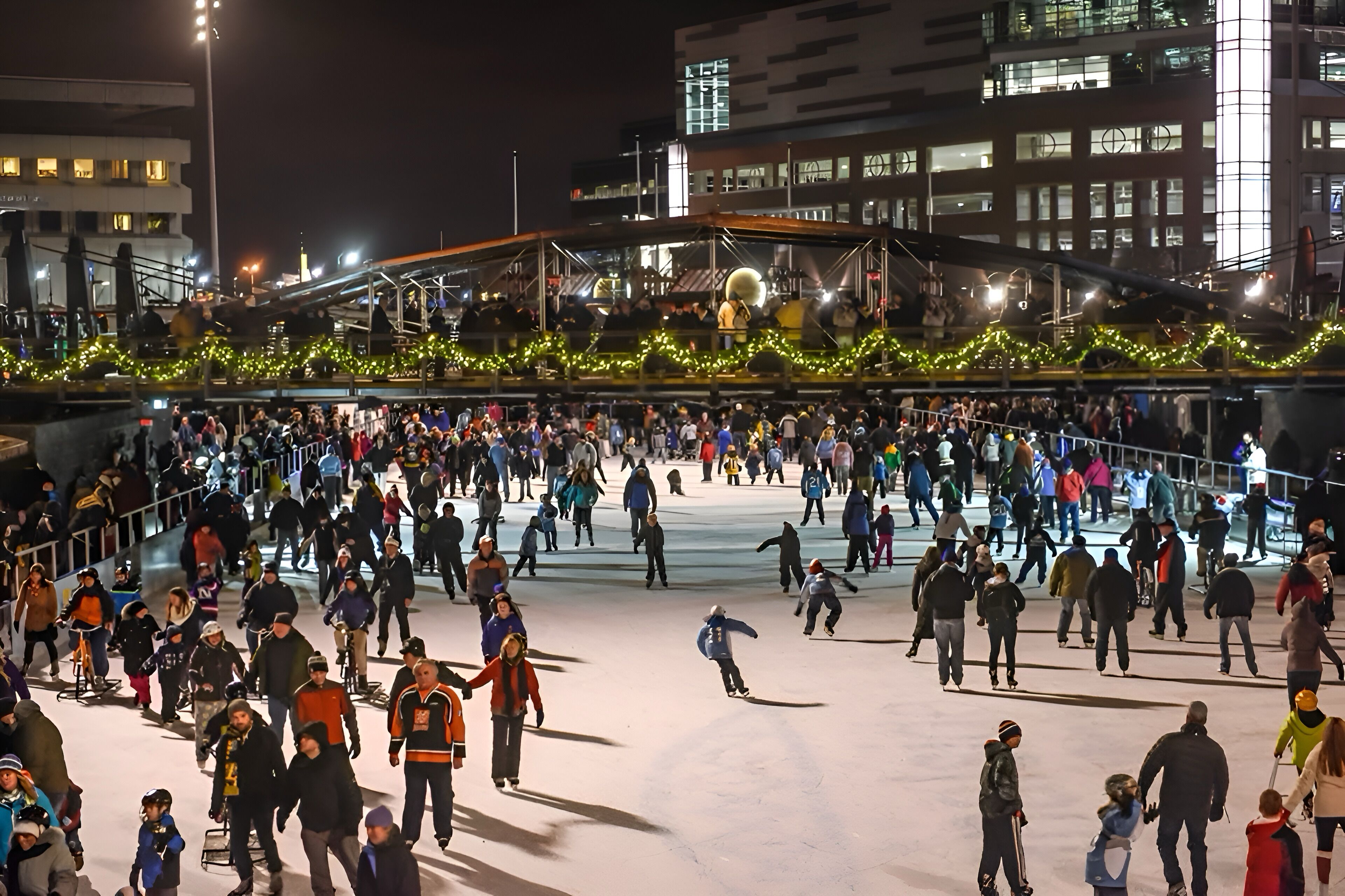 An outdoor ice skating rink surrounded by buildings.