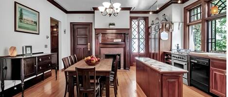 A spacious kitchen with wooden cabinetry, a central island, and a dining area with a table and chairs.