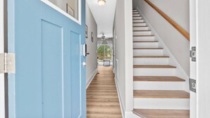 A hallway with a blue door, wooden stairs, and a ceiling fan. - Ducks Landing Accommodations at Southern Pines Golf Course (Aberdeen)