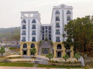 A multi-story hotel with a symmetrical facade, large windows, and a central staircase leading to the entrance.