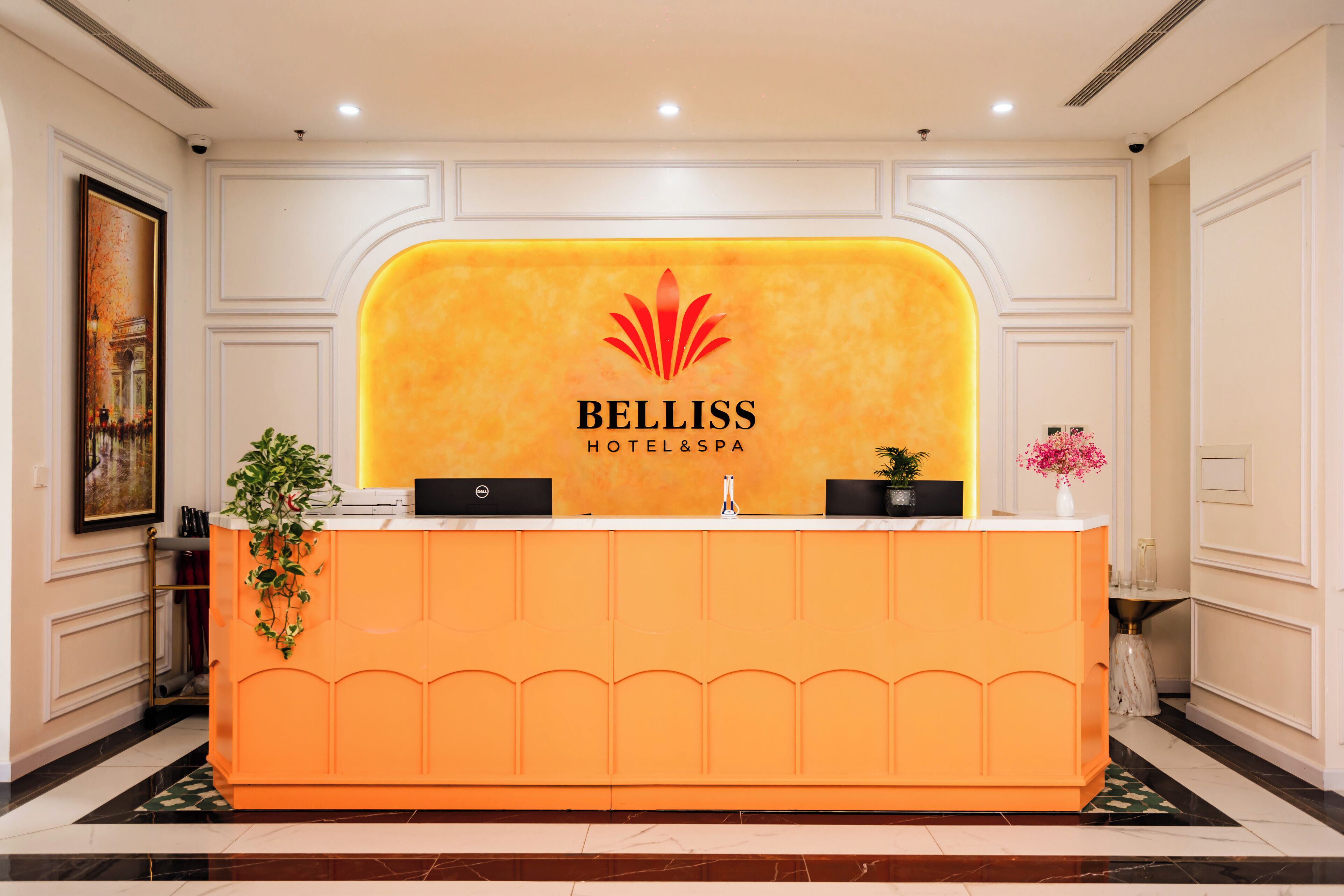 De receptie van Belliss Hotel & Spa, met een modern design, een opvallend logo en een warme kleurenschaal.