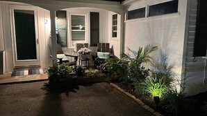 Ein Haus mit überdachter Terrasse, einer Tür und einem Fenster.