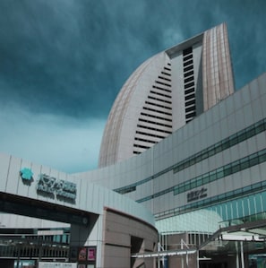 A modern building with a curved facade, large windows, and a prominent logo.