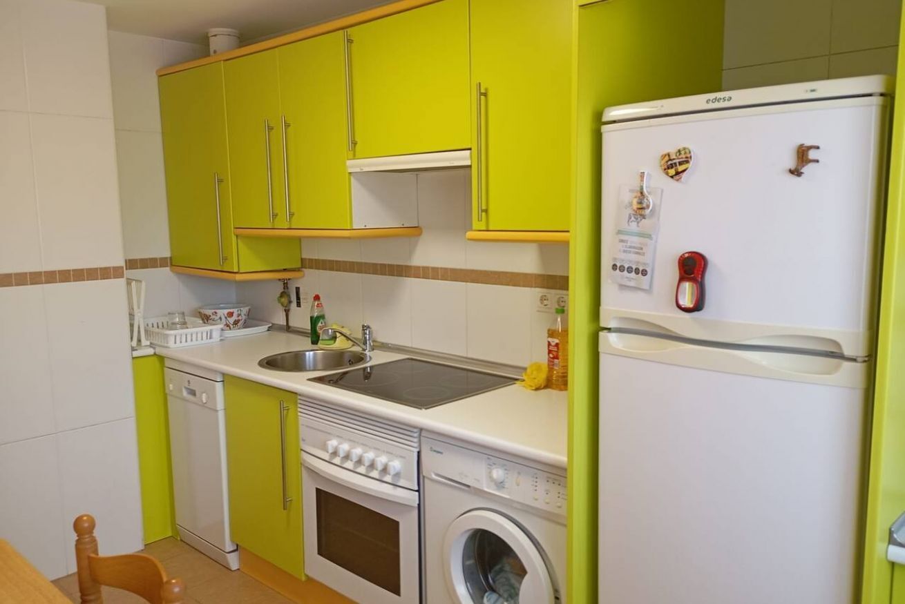 Eine kompakte Küche mit Spüle, Herd, Backofen und Waschmaschine.
