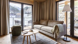 A modern living room with a sofa, a small round table, and a lamp. - Premium Suite mit 2 SZ & Mini-Spa by Interhome (Saalbach-Hinterglemm)
