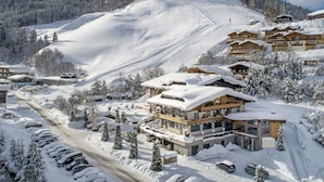 A snow-covered ski resort with multiple buildings, a ski slope, and a parking area. - Premium Suite mit 2 SZ & Mini-Spa by Interhome (Saalbach-Hinterglemm)