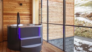 A sauna with a metallic base and a black handle, set against a wooden wall with a large window overlooking a snowy landscape. - Premium Suite mit 2 SZ & Mini-Spa by Interhome (Saalbach-Hinterglemm)