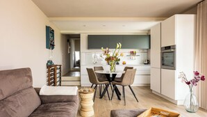 Ein modernes Wohnzimmer mit einer Couch, einem Couchtisch und einem Essbereich mit Stühlen und einem Tisch.