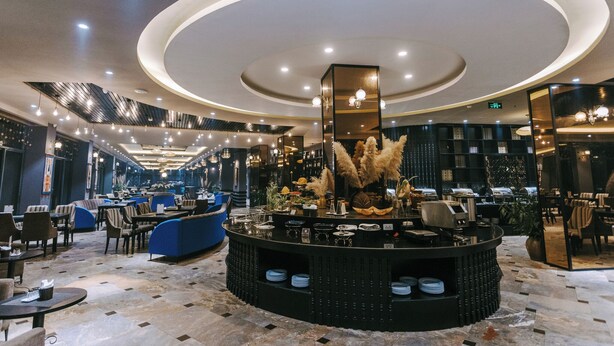 A modern hotel lobby with a circular bar area, seating arrangements, and a staircase leading to upper floors. - Sapa Charm Hotel (Sa Pa)