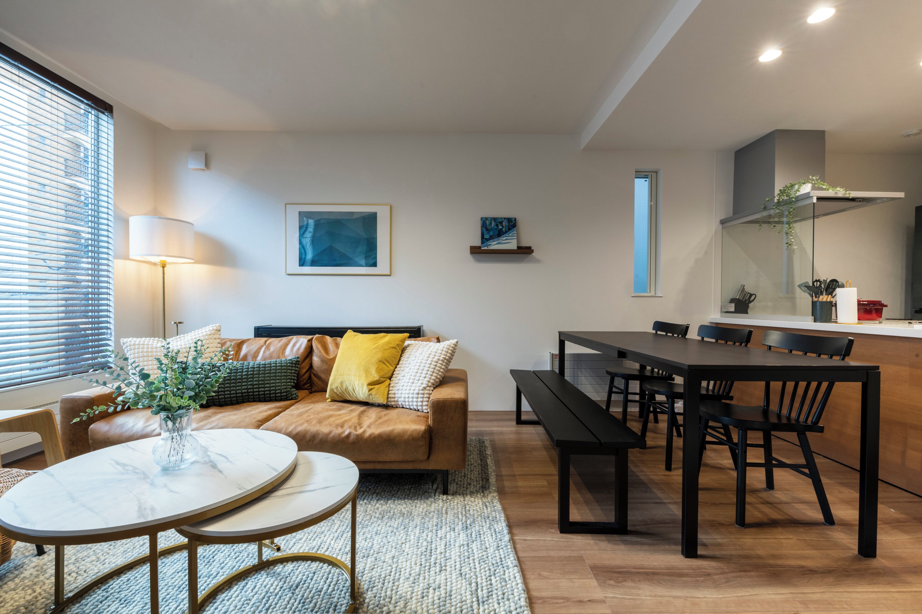 A modern living room with a sofa, coffee table, and dining area.