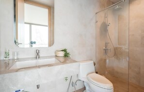 A modern bathroom with a marble sink, a toilet, and a glass-enclosed shower. - Sandbox Beachfront Villa3 (Bang Lamung)