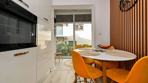 A modern kitchen with white cabinets, a black oven, and a large window. - DaLaPaDo by Interhome (Zadar)