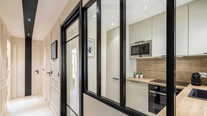 Eine moderne Küche mit Mikrowelle, Backofen und einer Holz Arbeitsplatte.