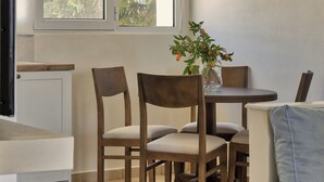 Een moderne eetruimte met een ronde tafel, houten stoelen en een hanglamp.