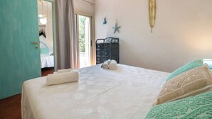 A bedroom with a bed, a dresser, a ceiling fan, and a view of the outside. - Porto Rotondo - Appartamento in Centro, 8 Minuti Da Spiaggia Ira (Olbia)