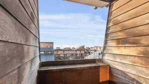 Varanda de madeira com vista para edifícios próximos.