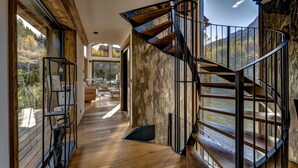 A spiral staircase with a view of a mountainous landscape, wooden flooring, and a modern interior design. - Serviced Luxury Chalet with 10m Indoor Pool (Chamonix-Mont-Blanc)