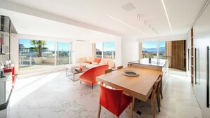 A modern living space with a dining area, a sofa, and a kitchen. - Sumptuous terrace apartment - Cannes - Sea view (Cannes)