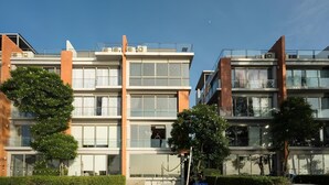 Ένα πολυώροφο κτίριο κατοικιών με μεγάλα παράθυρα, μπαλκόνια και καθαρό ουρανό.