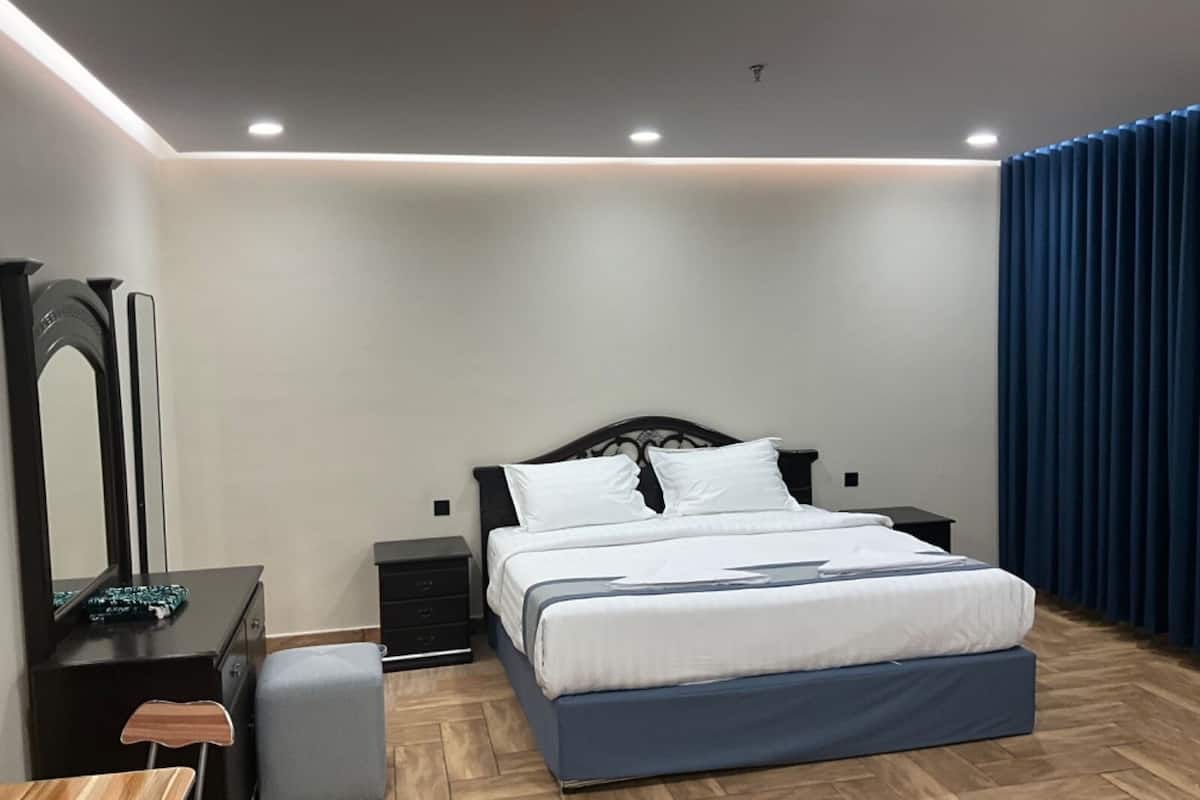 Une chambre à coucher moderne avec un lit, des tables de chevet, une commode et un miroir.