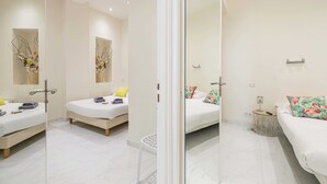 A modern hotel room with two beds, a glass partition, and a small side table with a lamp. - Beautiful Two bedroom apartment near Croisette (Cannes)