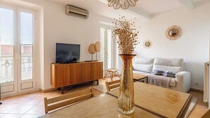 Een moderne woonkamer met een houten kast, een televisie, een bank en een salontafel.