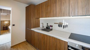 A modern kitchen with wooden cabinets, a stainless steel sink, and a built-in oven.