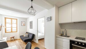 En moderne lejlighed med et køkken, spiseområde og en stue med sofa og et lille bord.