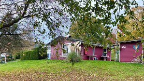 Un bâtiment rouge avec le numéro « 22 » sur le côté, un petit porche avec des chaises et un drapeau.
