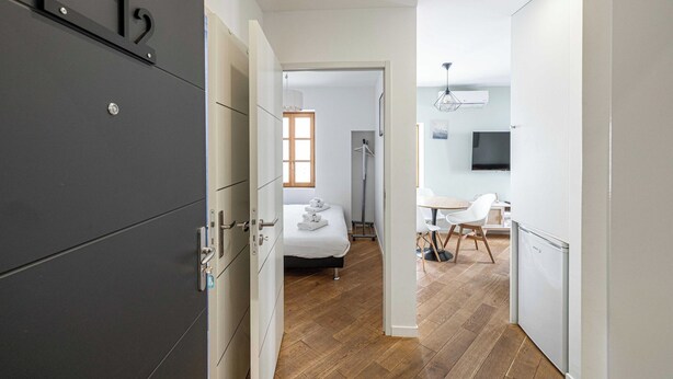 Habitació d'hotel moderna amb llit, escriptori i cadira. Hi ha un armari amb el símbol del número.